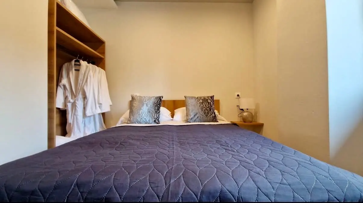 Franciaágy az 51-es apartmanban, a nyitott gardróbban fürdőköpenyekkel
